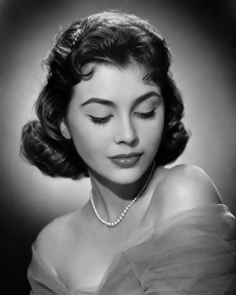 AI Old Photo Revival scene — a 1950s woman in a restored black-and-white portrait with a soft blink