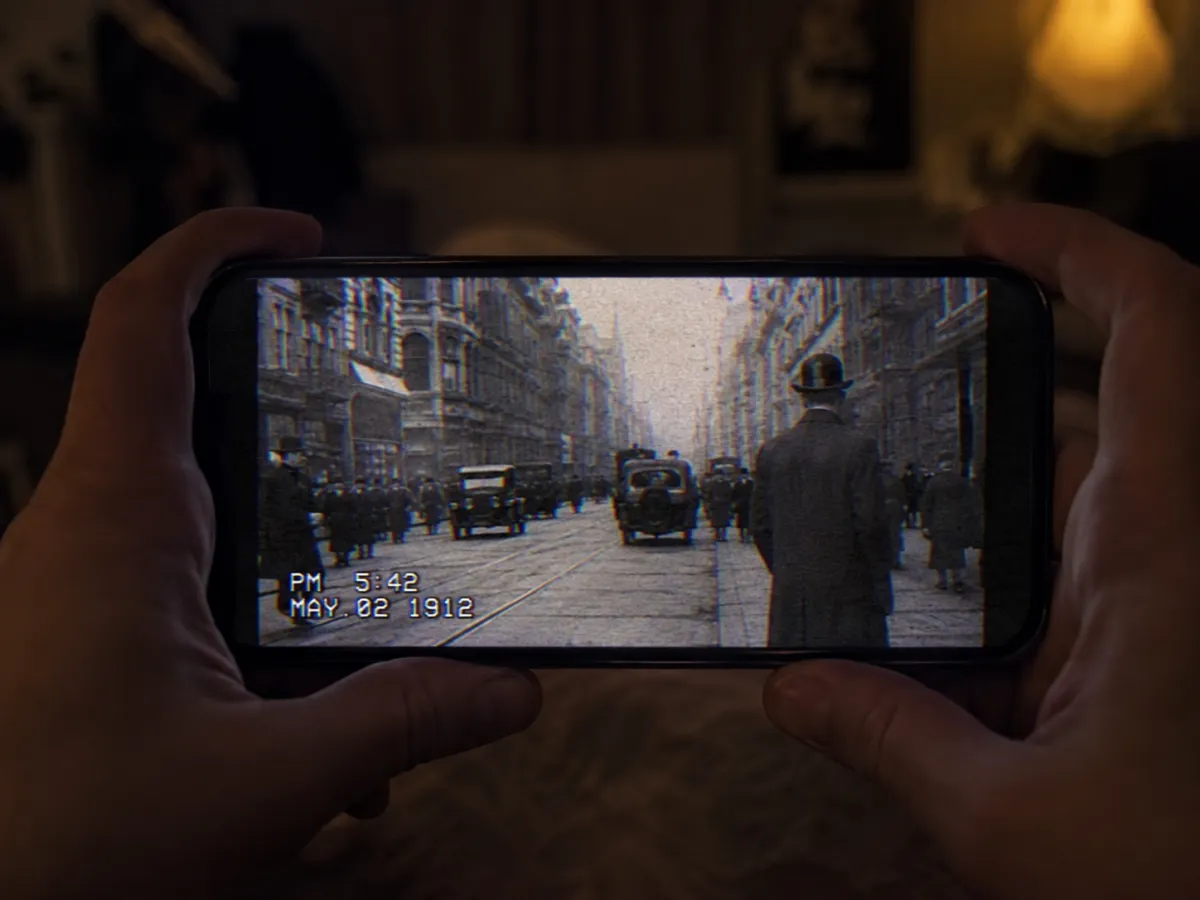 Watching an AI time travel video found-footage clip of a 1918 street on a phone