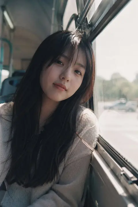 Japanese film-style girl looking through a rain-streaked bus window